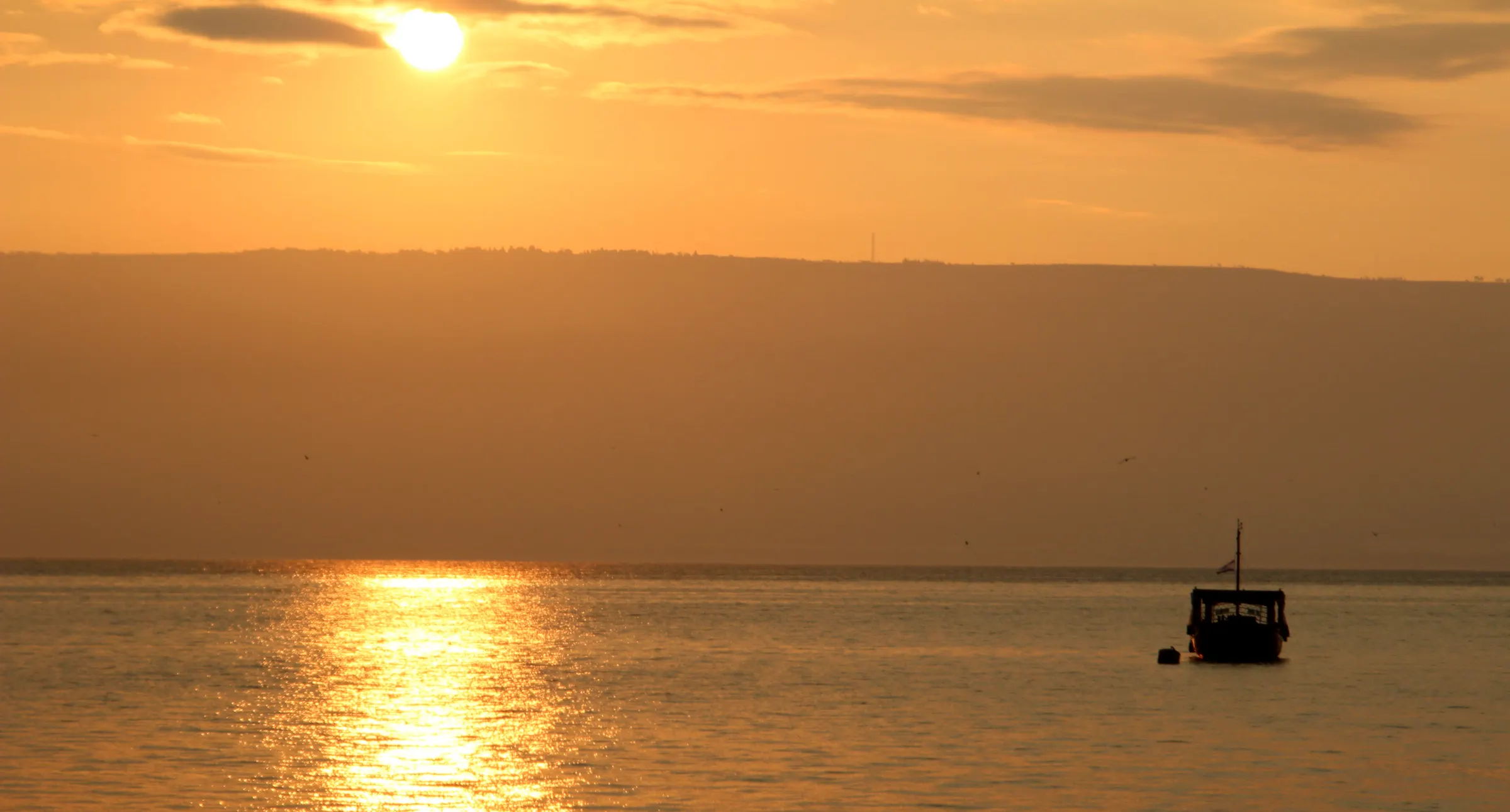 Sunrise over the Sea of Galilee, with a fishing boat